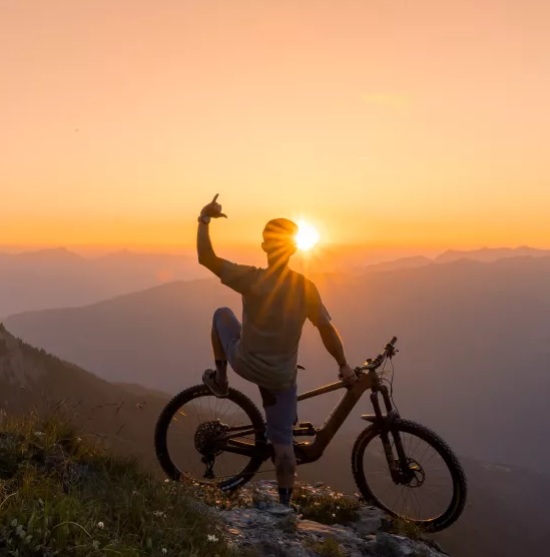 jeune homme vtt devant le coucher du soleil